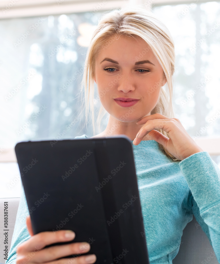 Young woman using her tablet computer at home