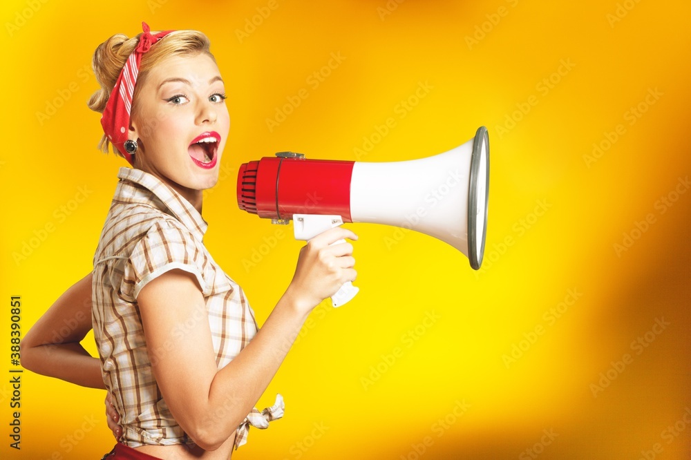 Beautiful woman holding megaphone and screams