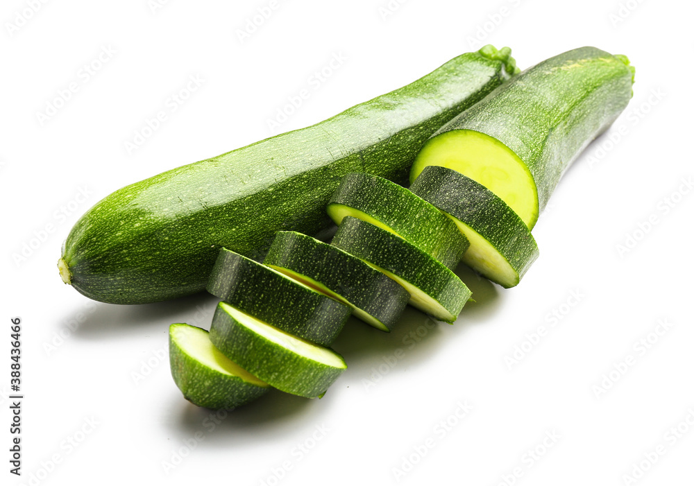 Fresh zucchini squashes with slices on white background