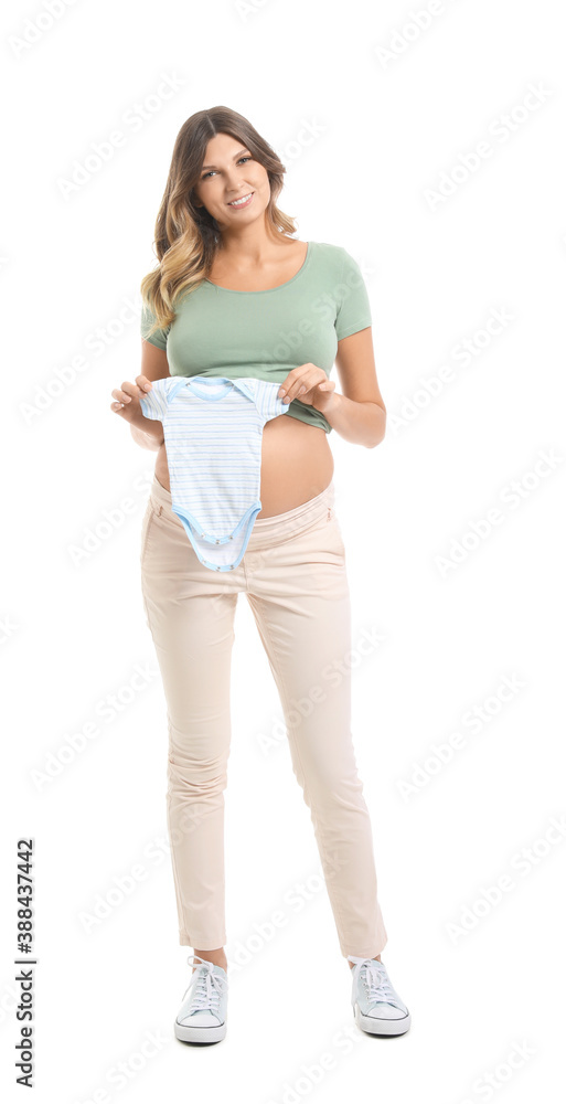 Beautiful pregnant woman with baby clothes on white background