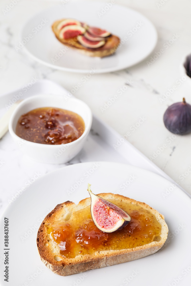 Plate with tasty sandwich with fig jam on table