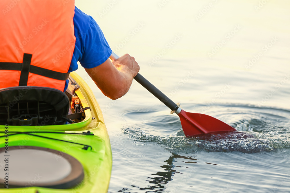 Young man kayaking in river