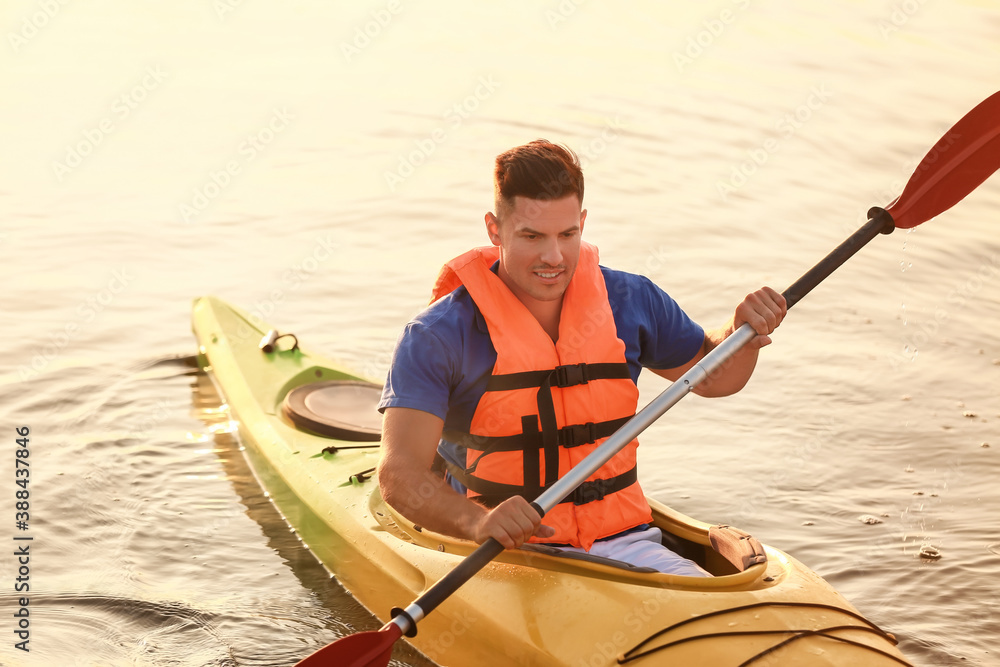 Young man kayaking in river