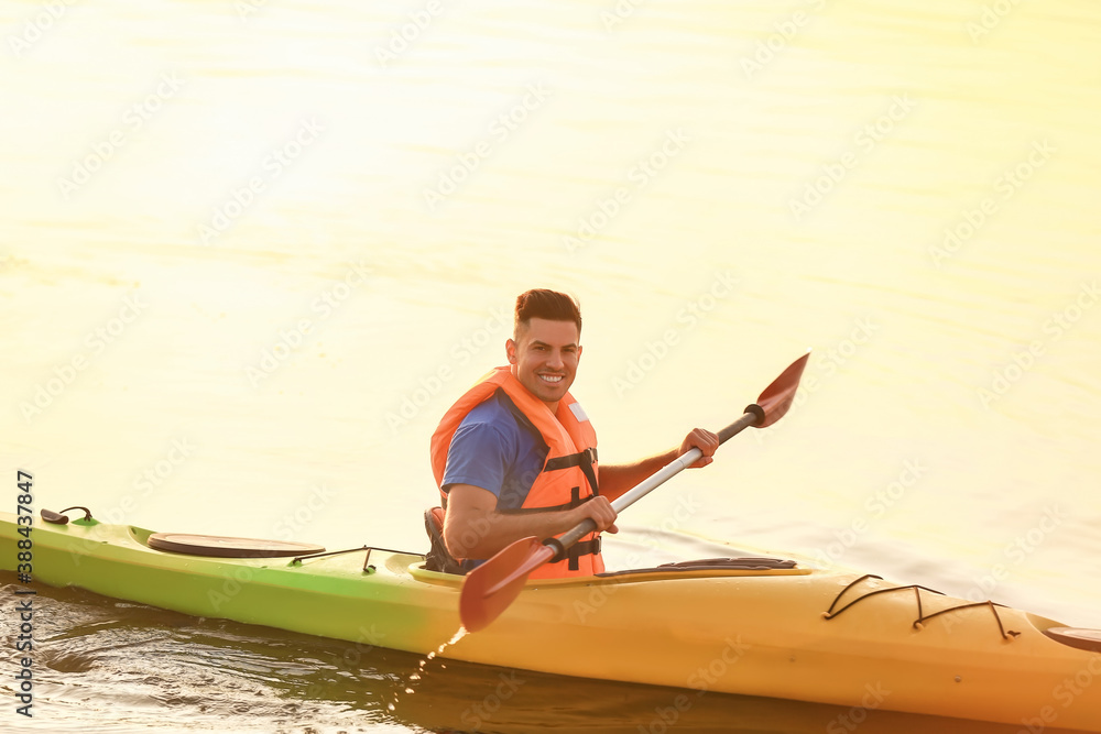 Young man kayaking in river