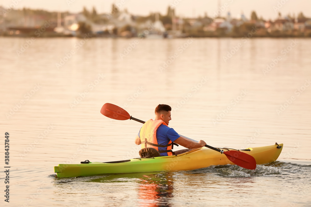 Young man kayaking in river