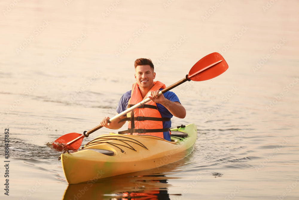 Young man kayaking in river