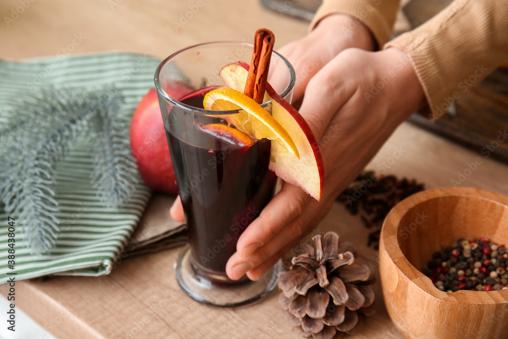 Woman with tasty mulled wine at home, closeup