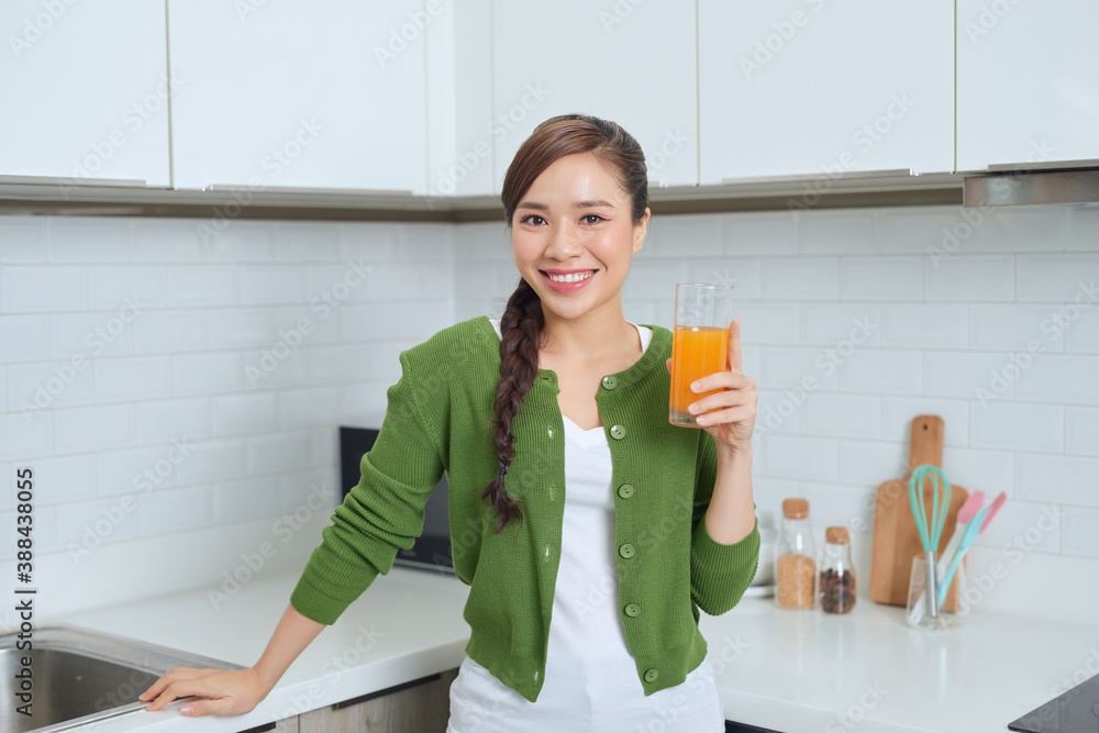 Young healthy asian woman drinking orange juice