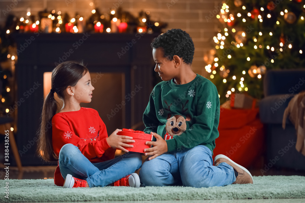 Cute children with gift at home on Christmas eve