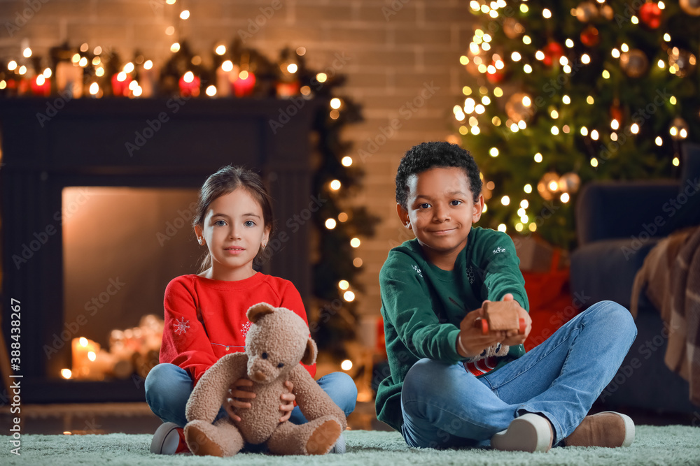 Cute children with toys at home on Christmas eve