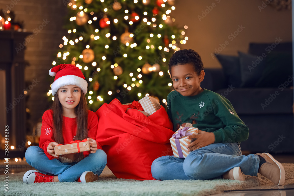 Cute children with gifts at home on Christmas eve