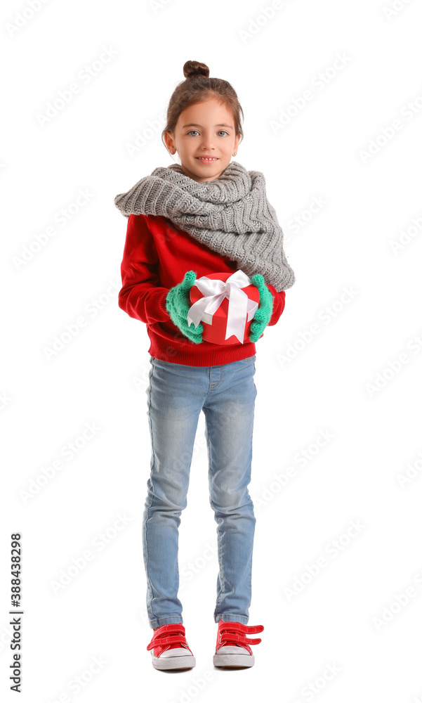 Cute girl in winter clothes and with gift on white background