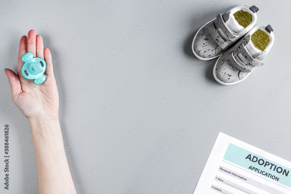 adoption form and children shoes on desk background top view mock up