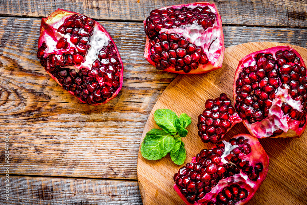 sliced pomegranate on wooden background top view