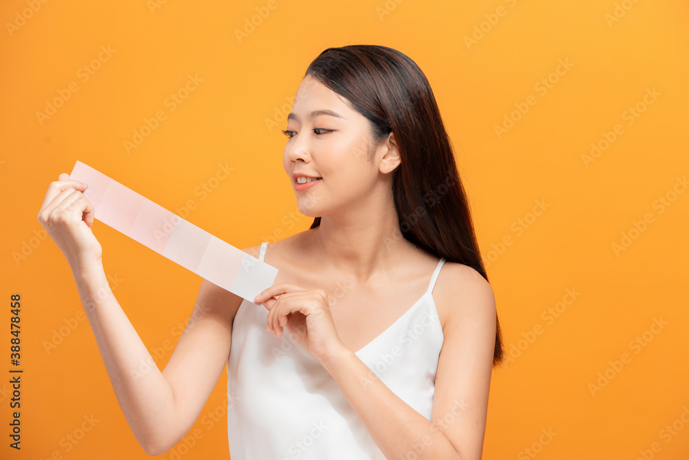 Young woman with paint palette on color background