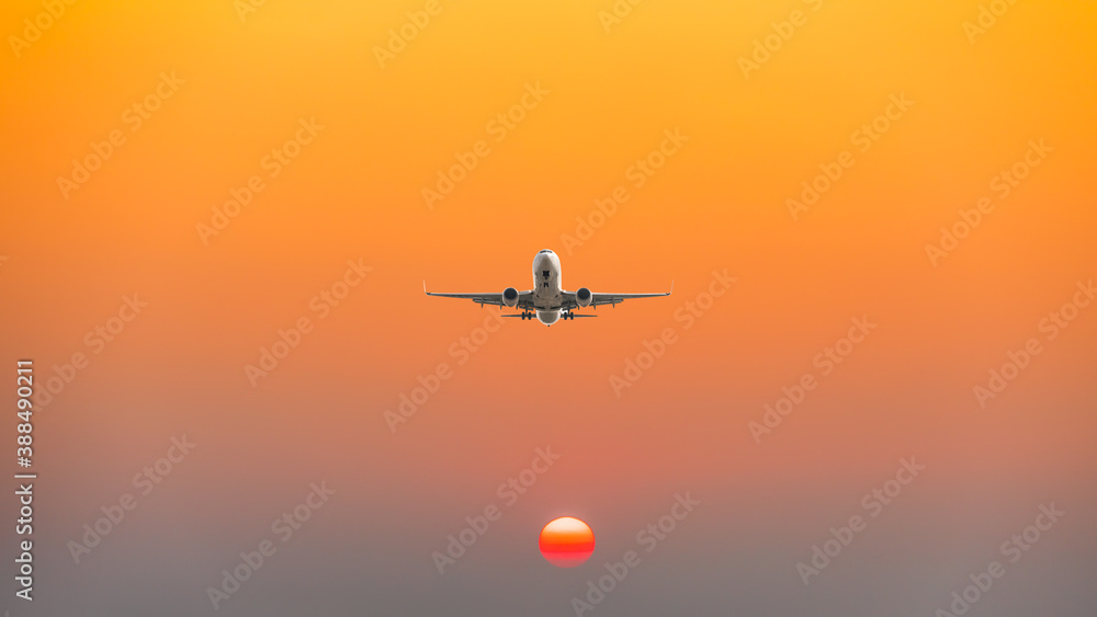 Commercial airplane flying above clouds in colorful sunset.Travel,holidays and business concept.