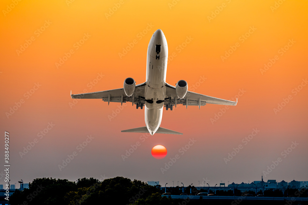 Commercial airplane flying above clouds in colorful sunset.Travel,holidays and business concept.