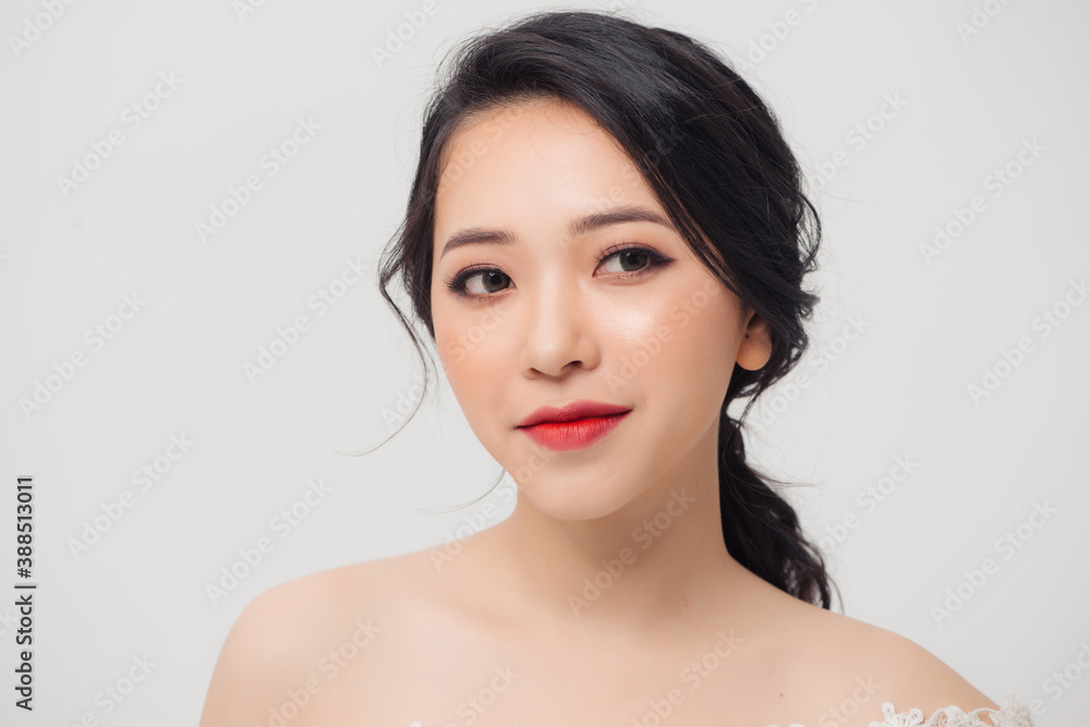 Portrait of young elegant Asian woman with white dress isolated on light background.