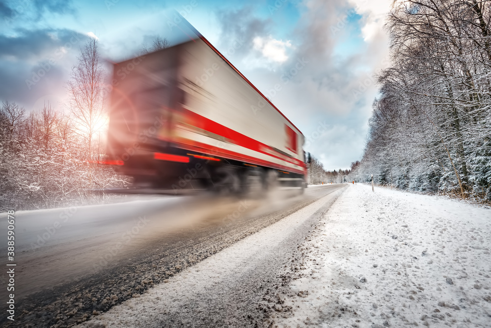 Truck on asphalt road in winter on sunny morning