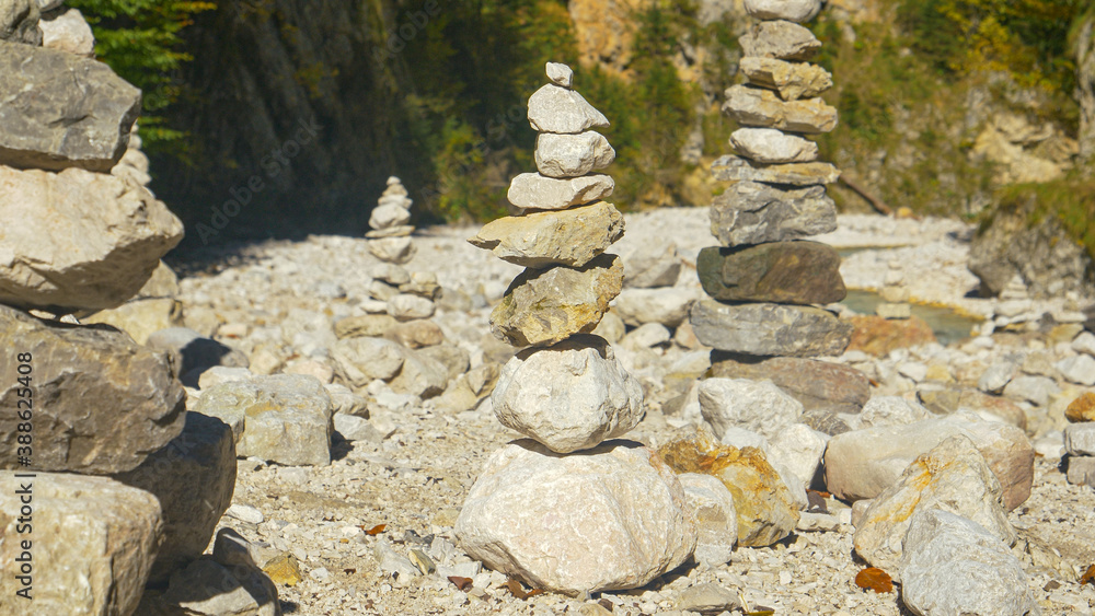 CLOSE UP: Stone towers ornate the coastline of a mountain river in Kranjska Gora