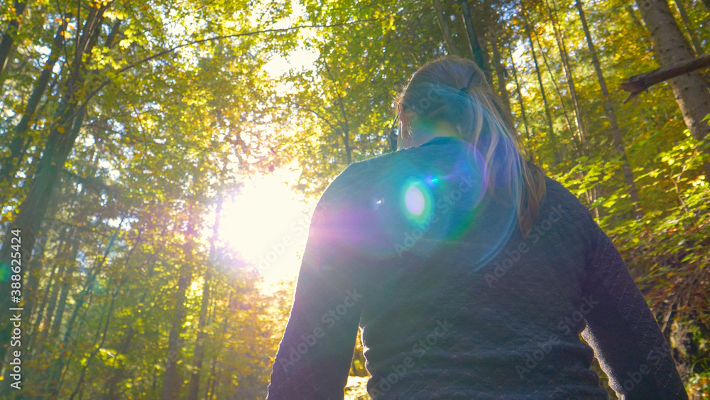 CLOSE UP: Girl enjoys a relaxing trek around a tranquil forest changing colors.