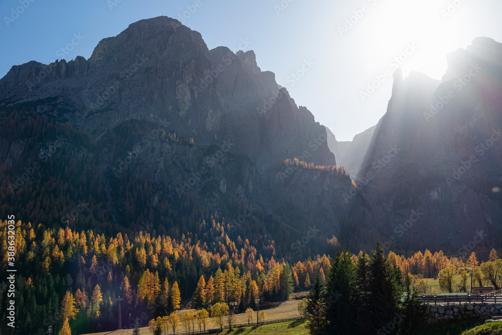 LENS FLARE: Bright autumn sunbeams shine on the rocky peaks of the Dolomites.