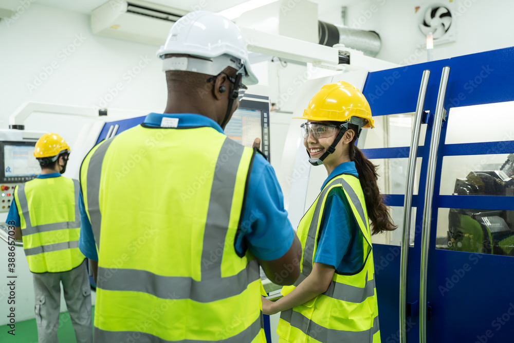 African Engineer Man talking to female worker in operating room.