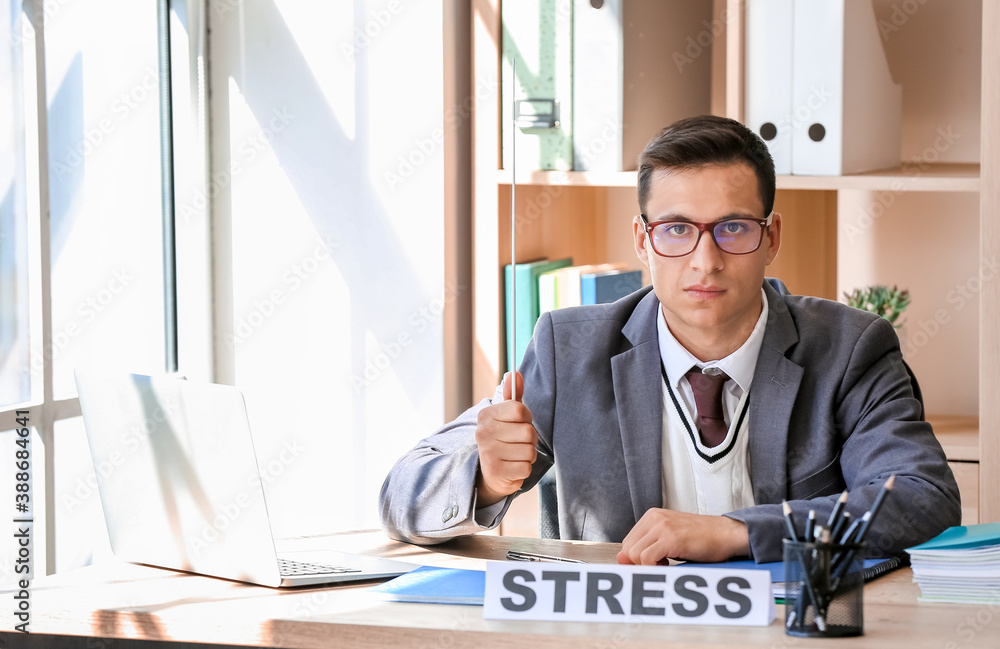 Stressed young male teacher in classroom