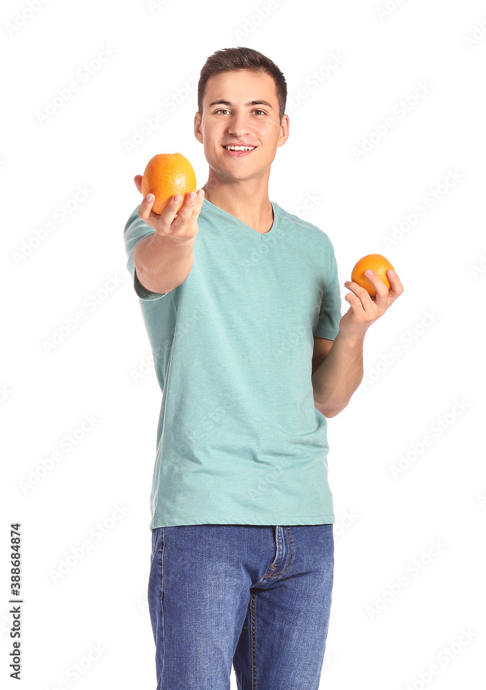 Handsome man with ripe oranges on white background