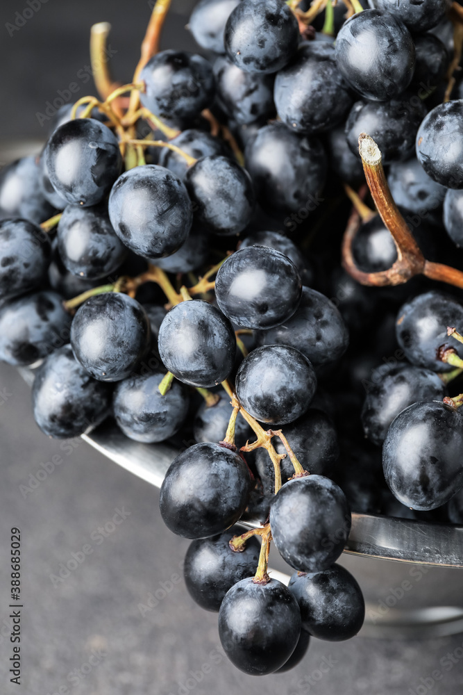 Sweet ripe grapes in colander on table, closeup