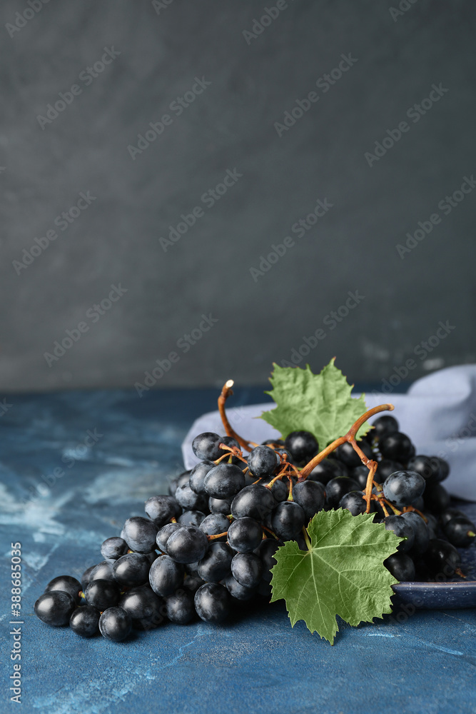 Plate with sweet ripe grapes on table