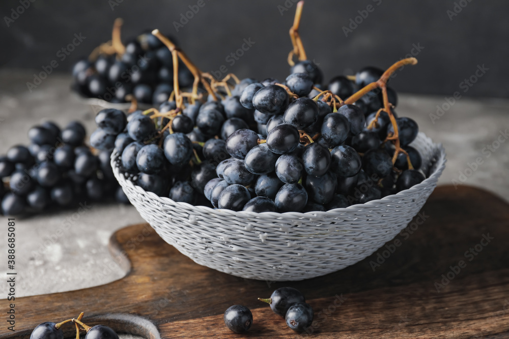 Bowl with sweet ripe grapes on table