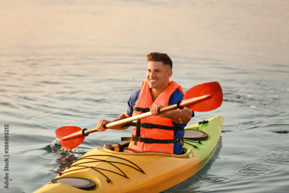 Young man kayaking in river