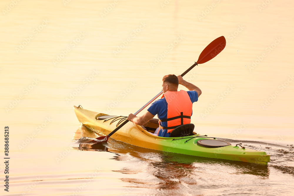 Young man kayaking in river