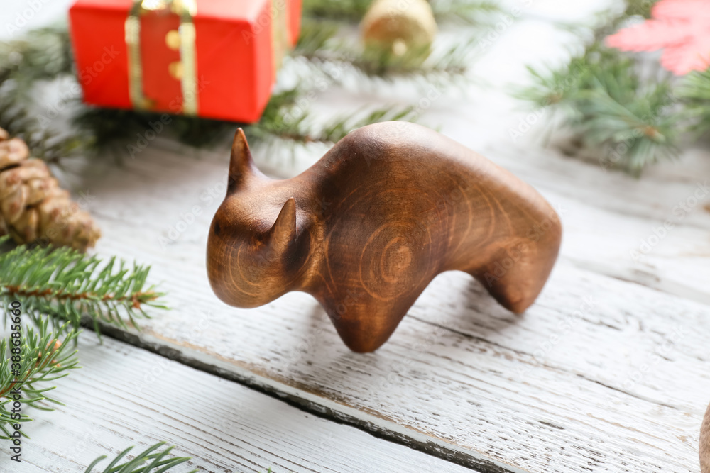 Figurine of bull and New Year decor on wooden background