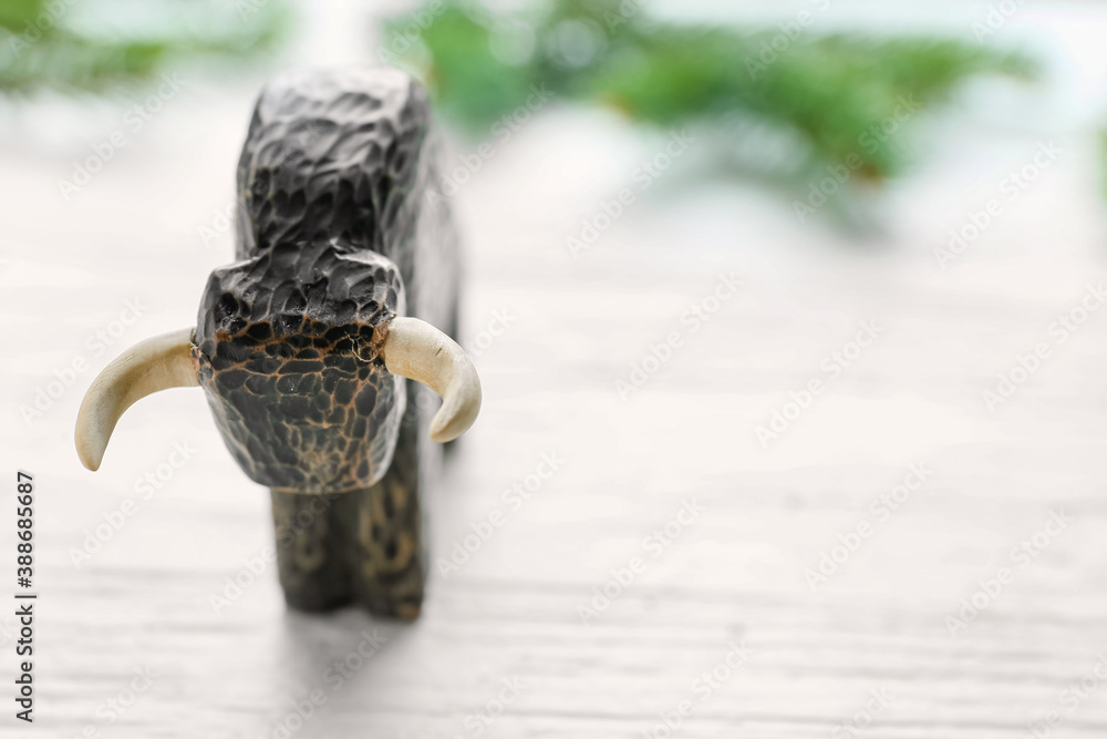 Figurine of bull and New Year decor on wooden background