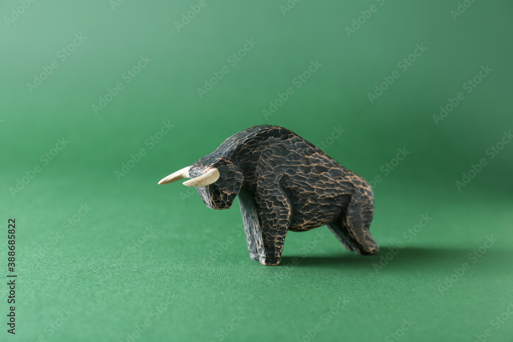 Figurine of bull as symbol of year 2021 on color background