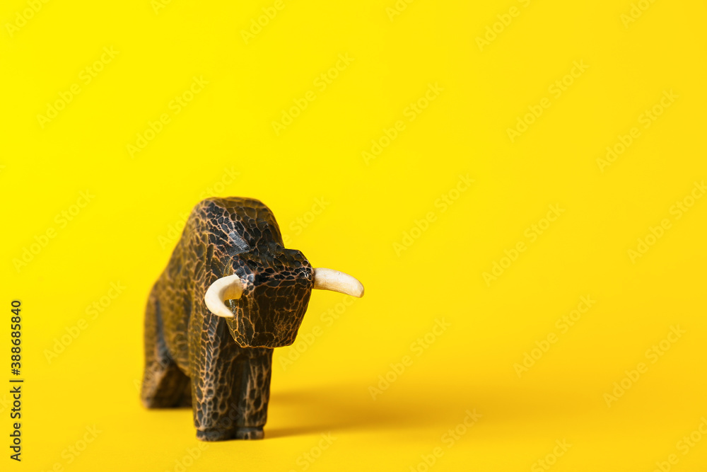 Figurine of bull as symbol of year 2021 on color background