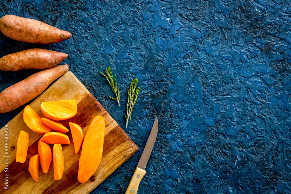 Sweet potato - sliced yams organic vegetables on cutting board, view from above