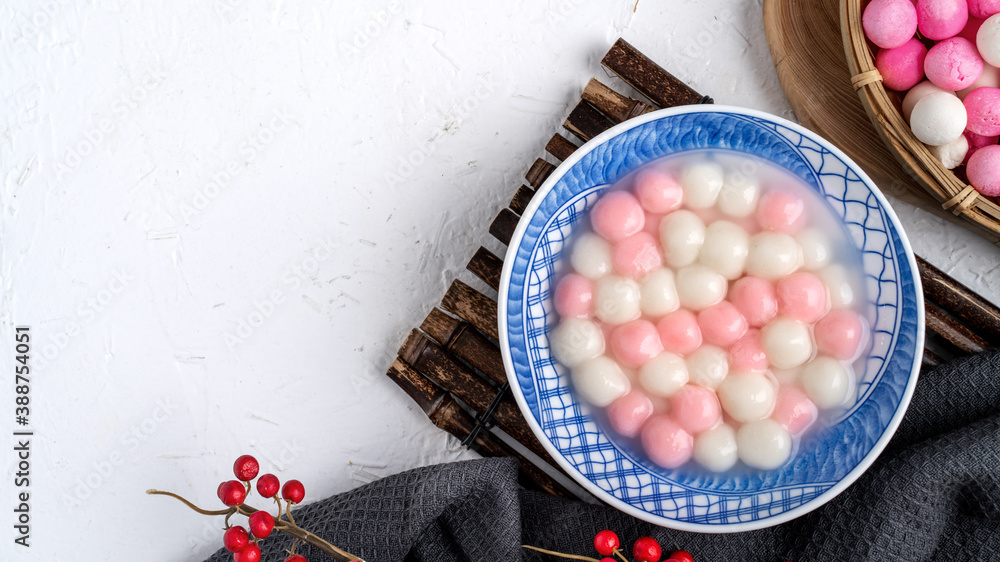 Top view of red and white tangyuan in blue bowl on white background for Winter solstice.