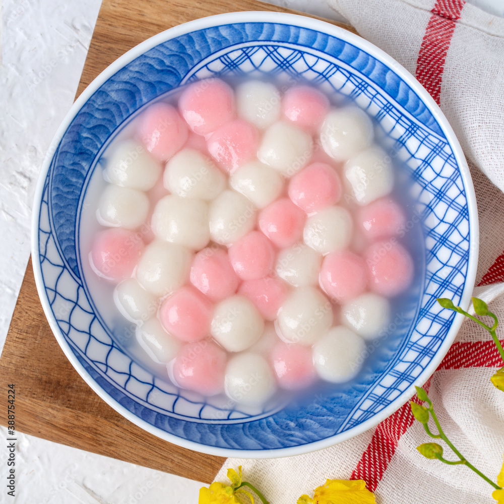 Top view of red and white tangyuan in blue bowl on white background for Winter solstice.