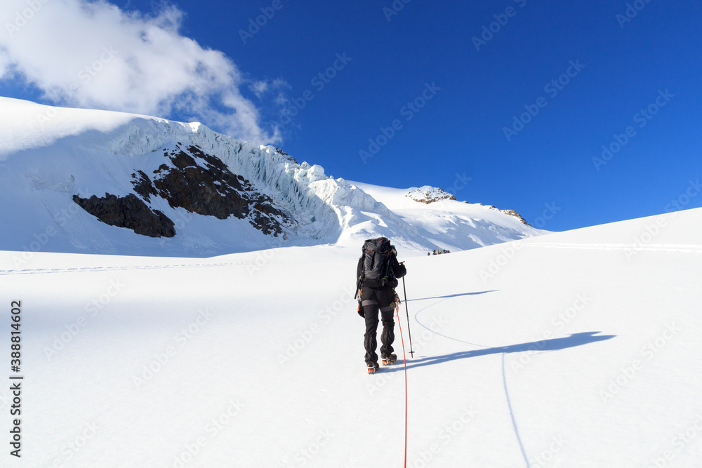 Rope team mountaineering with crampons on glacier Taschachferner towards Wildspitze and mountain sno