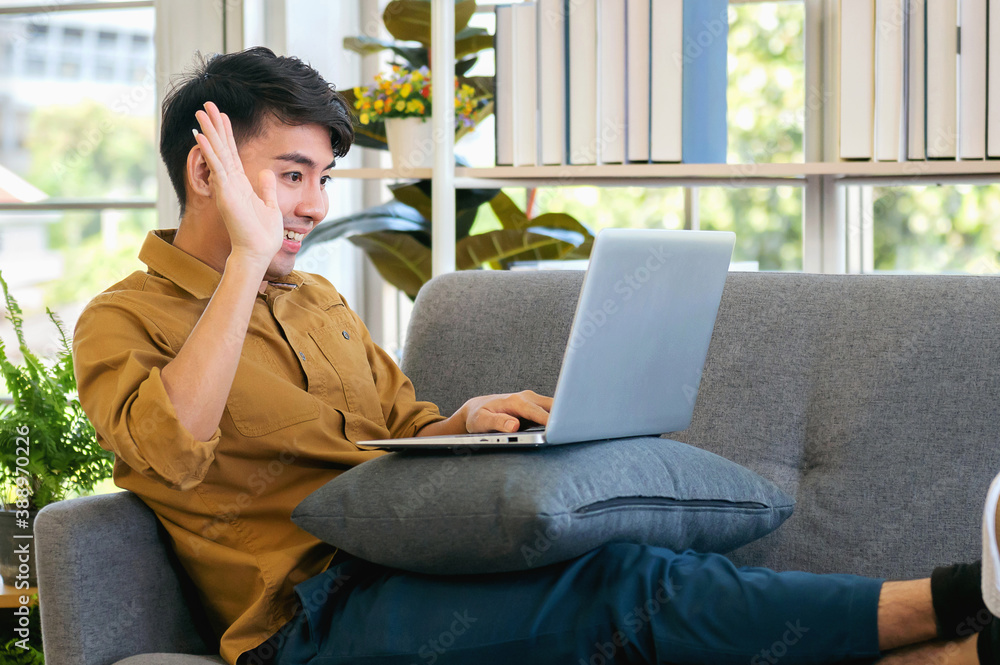 young man smiling making video call to friend at home