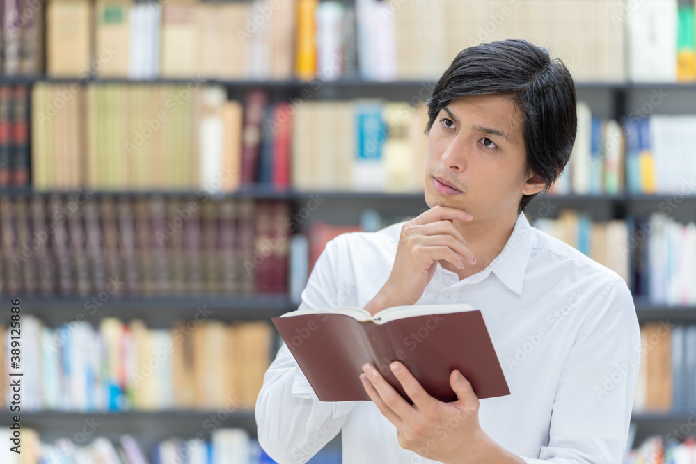 図書館で考え事をする男性