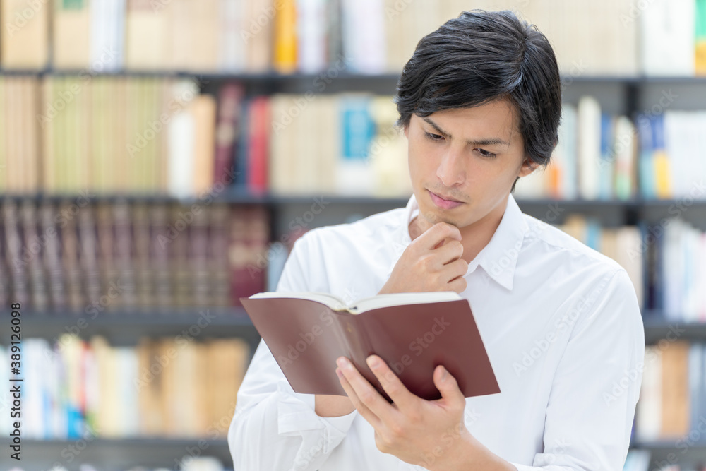 図書館で考え事をする男性