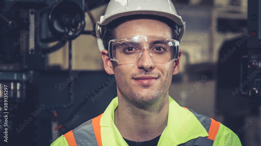 Young factory worker or engineer close up portrait in factory . Industry and engineering concept .