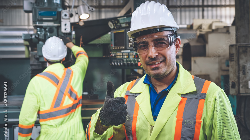 Young factory worker or engineer close up portrait in factory . Industry and engineering concept .