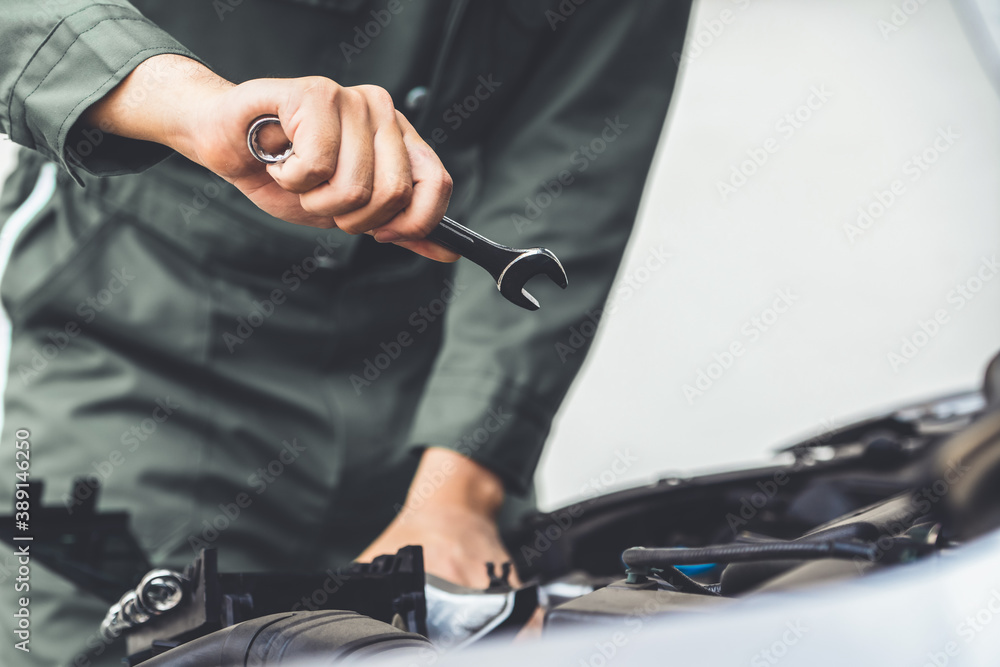 Professional mechanic hand providing car repair and maintenance service in auto garage. Car service 