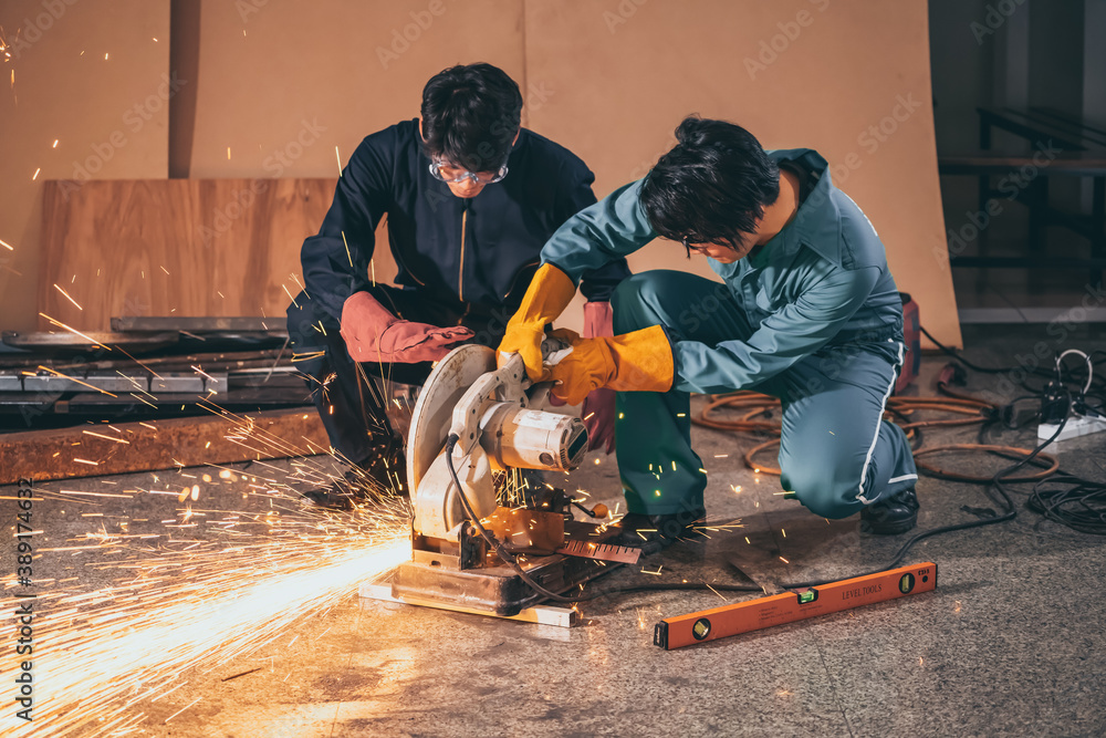 Professional mechanic man is cutting steel metal with rotating carbon blade cutter. Steel industry a