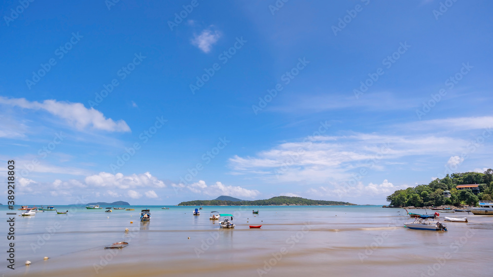 Tropical beach with LongTail boats in the sea blue sky and white clouds in summer season.